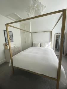 ロンドンにあるQueen bedroom in Maida Valeのベッドルーム(白いシーツを使用した天蓋付きベッド1台付)