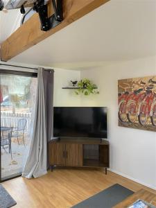a living room with a flat screen tv on a wall at Bluebird Day - River Gem Bungalow in Bend