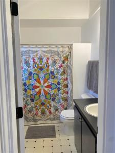 a bathroom with a mosaic shower curtain with a toilet at Bluebird Day - River Gem Bungalow in Bend +16 photos