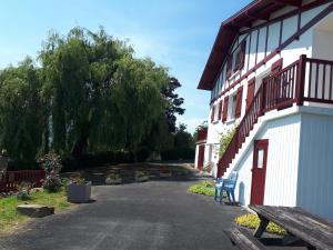 a bench next to a building with a tree at Maison GAINEKO ETXEA in Ostabat-Asme