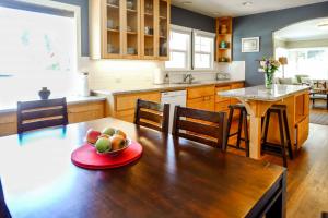 a kitchen with a table with a bowl of fruit on it at Bluebird Day - Riverside Cottage in Bend