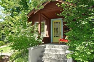 una piccola casa con una panchina rossa sul portico di Bluebird Day - Jefferson Cottage a Bend