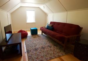 a living room with a red couch and a window at Bluebird Day - Hill Street Beauty in Bend