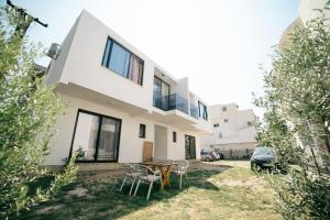 a house with a table and chairs in the yard at Rine Apartments in Ulcinj