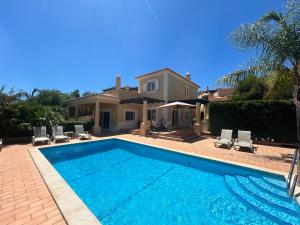 a large swimming pool in front of a house at Perfect Golf & Beach Villa for 8 people in Estômbar