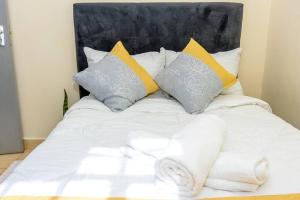 a bed with white sheets and pillows on it at The sunset in Nanyuki