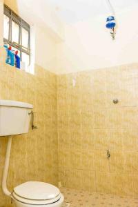 a bathroom with a white toilet and a window at The sunset in Nanyuki