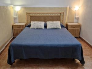 a bedroom with a blue bed with two night stands at Casolare Al Porto in Tropea
