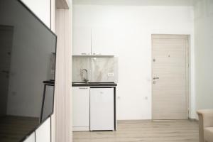 a kitchen with white cabinets and a sink at Rine Apartments in Ulcinj