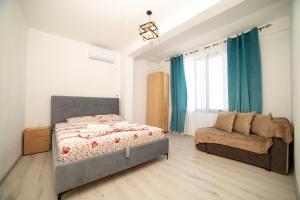 a bedroom with a bed and a couch at Rine Apartments in Ulcinj