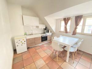 eine Küche mit einem weißen Tisch und weißen Geräten in der Unterkunft Oldtown Apartment Andreasstrasse in Düsseldorf + 32 Fotos