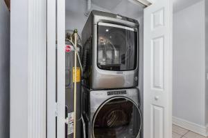 a washer and dryer in a room next to a door at Casa Historia Sleek 2B apt UNIQUE spot downtown in Fort Myers