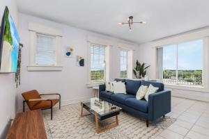 a living room with a blue couch and a table at Casa Palma Historic apt in the BEST spot downtown in Fort Myers