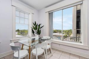 a dining room with a table and chairs and a window at Casa Palma Historic apt in the BEST spot downtown in Fort Myers