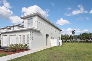 a large white house with a grass yard at Gorgeous Townhome Close to the beaches in Fort Myers