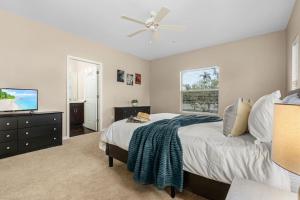 a bedroom with a bed and a flat screen tv at Gorgeous Townhome Close to the beaches in Fort Myers +15 photos
