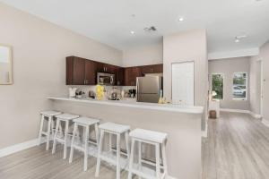 a kitchen with a bar with stools in it at Modern Townhouse close to beaches in Fort Myers
