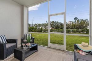 a living room with a view of a green field at Modern Townhouse close to beaches in Fort Myers