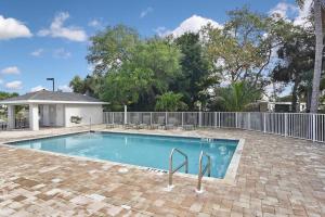 a swimming pool in a yard with a fence at Modern Townhouse close to beaches in Fort Myers