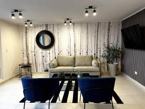 a living room with a couch and blue chairs at Departamento Mono - Ambiente in Osorno