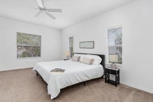 a white bedroom with a bed and a ceiling fan at Hideaway at Hidden Palms Cove in Fort Myers +20 photos