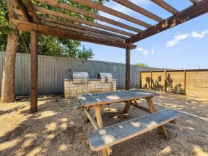 a wooden picnic table under a wooden pergola at Mins 2 Dwntown - Private Stay - Nestled Austin Pad in Austin