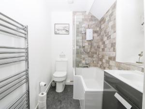 a white bathroom with a toilet and a sink at Penrallt in Betws-y-coed +19 photos