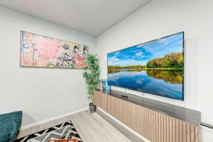 a living room with a large screen tv on a wall at Cozy Modernized Home - Minutes to Downtown-AUS in Austin