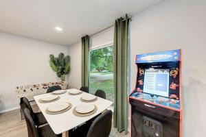 a dining room with a table and a video game at Pink Fun Home - Minutes to Downtown-AUS in Austin