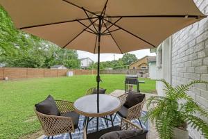 a table and chairs with an umbrella on a patio at Pink Fun Home - Minutes to Downtown-AUS in Austin