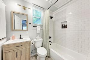 a white bathroom with a toilet and a sink at Pink Fun Home - Minutes to Downtown-AUS in Austin +15 photos