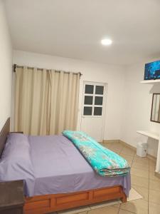 Un dormitorio con una cama con una manta azul encima. en Cortes Hermanos, en La Cal