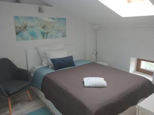 a small bedroom with a bed and a chair at Apartament krakowski GIMO na Kazimierzu in Krakow