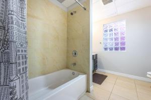 a white bathroom with a tub and a window at Bright 1BR Apt with Niagara Falls and Scenic Stay in Niagara Falls