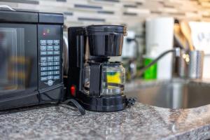 a coffee maker sitting on a counter next to a microwave at Bright 1BR Apt with Niagara Falls and Scenic Stay in Niagara Falls
