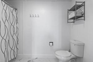 Un baño blanco con un inodoro y un estante. en Cozy King Suite Steps to the Beach (441), en Old Orchard Beach 11 fotos más