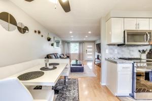 a kitchen and living room with white cabinets and a table at Boise Home with Hot Tub, Yard about 5 Mi to Dtwn! in Boise