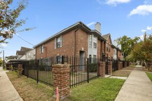 a brick house with a wrought iron fence at Walkable Montrose 2BR Houston Mural Sleeps 9 in Houston
