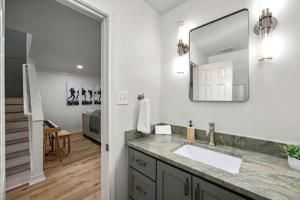 a bathroom with a sink and a mirror at Walkable Montrose 2BR Music Retreat Sleeps 10 in Houston +28 photos