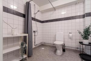 uma casa de banho em azulejos brancos com um WC e um chuveiro em Budget studio in hip SoFo - construction work em Estocolmo