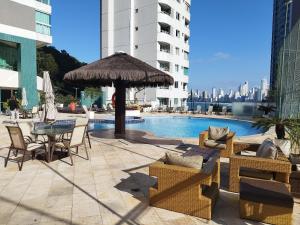 a patio with a table and chairs next to a pool at Terraços da Rainha AP1103 - Vista Espetacular - BC in Cabeçudas