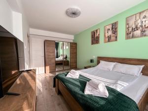 布拉索夫Mirandis Apartments - Modern Stays with Free Parking near Coresi Mall的一间卧室配有一张带白色床单和镜子的床
