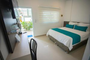 a bedroom with a large bed with blue pillows at Hotel Poblado Coveñas in Coveñas