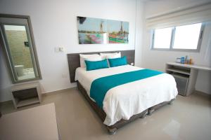 a bedroom with a large bed with blue pillows at Hotel Poblado Coveñas in Coveñas