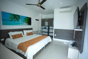a bedroom with a bed and a ceiling fan at Hotel Poblado Coveñas in Coveñas