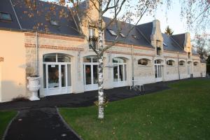 Pontavert的住宿－Logis Hotel Chemin Des Dames Le Relais De Fleurette，前面有棵树的建筑