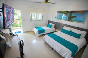 een slaapkamer met twee bedden en een flatscreen-tv bij Hotel Poblado Coveñas in Coveñas +55 foto's