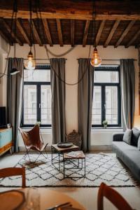 a living room with a couch and chairs and windows at Appart'24 Cosy au centre de Huy in Huy