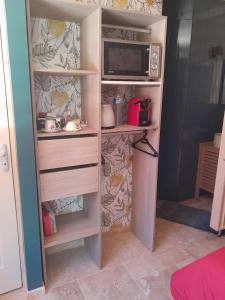 a cupboard with a microwave and a microwave at Love-Room Spa de la TRUFFIERE in Bertric-Burée