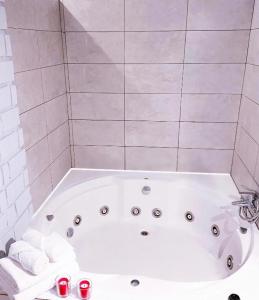 Una bañera blanca en un baño con toallas. en Hostal El Castillo Alcala De Guadaira, en Alcalá de Guadaira 13 fotos más